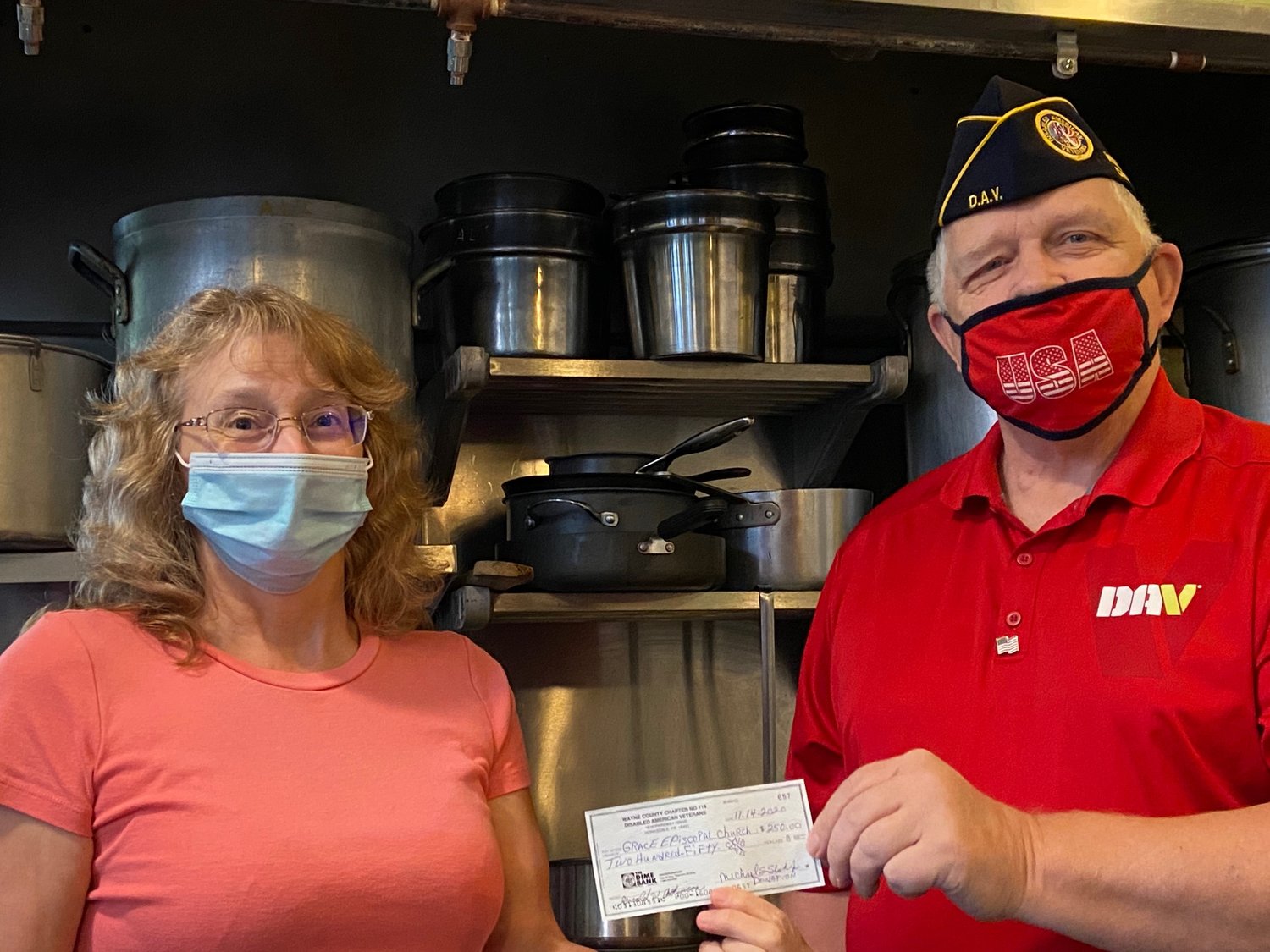 Mike Slish, treasurer of Wayne County Chapter 114 of the Disabled American Veterans, presents a $250 check to Laura Dyser, Thanksgiving Together chairperson, to help support the program.